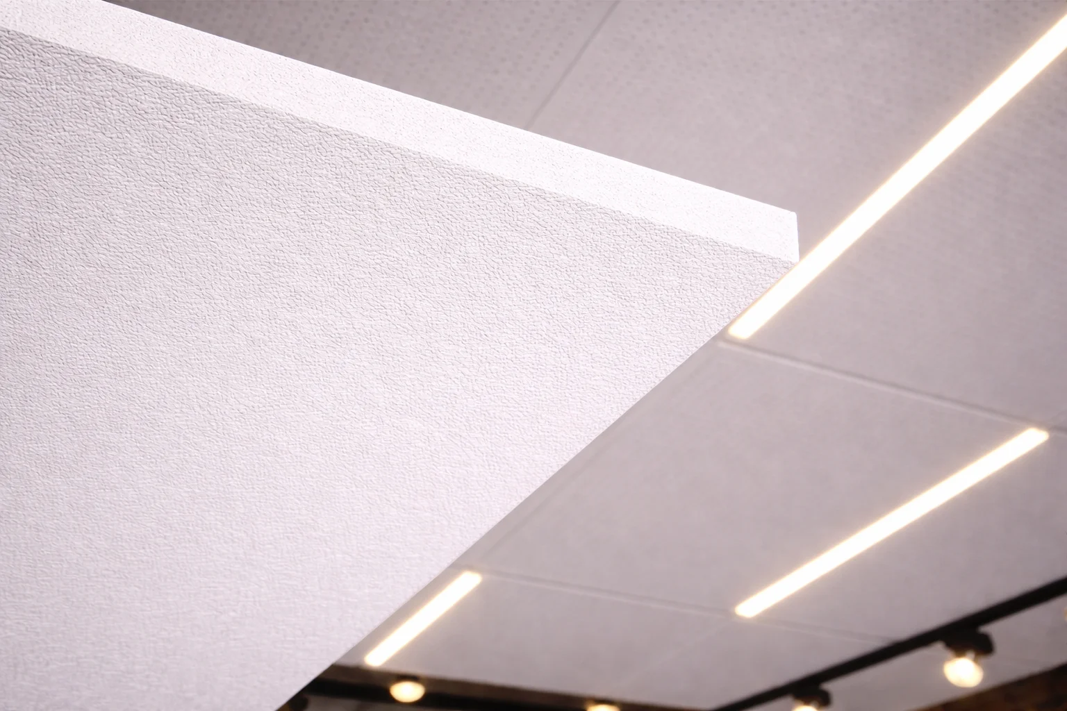 Close-up of perforated aluminium ceiling panel finish with integrated LED strip lighting