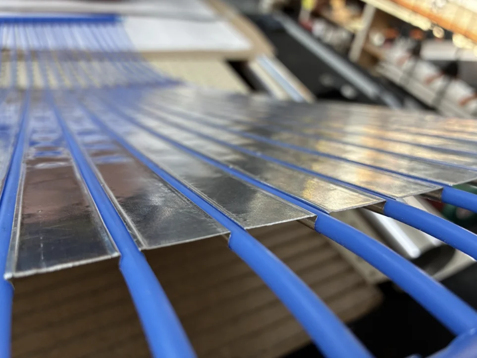 Close-up of omega-formed aluminium encapsulating capillary tubes from above