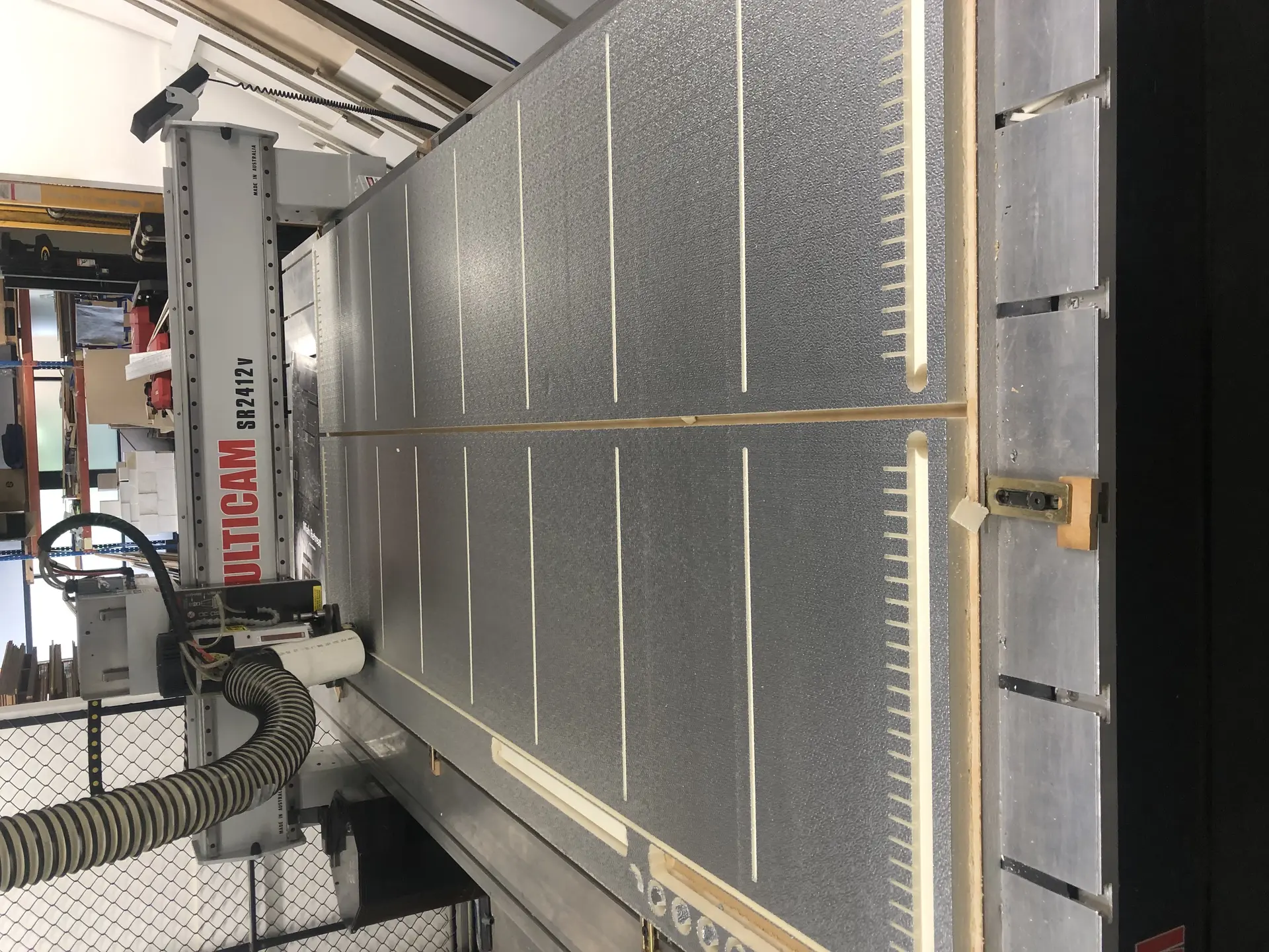 CNC router cutting foil-faced insulation panels to size on a vertical Multicam machine