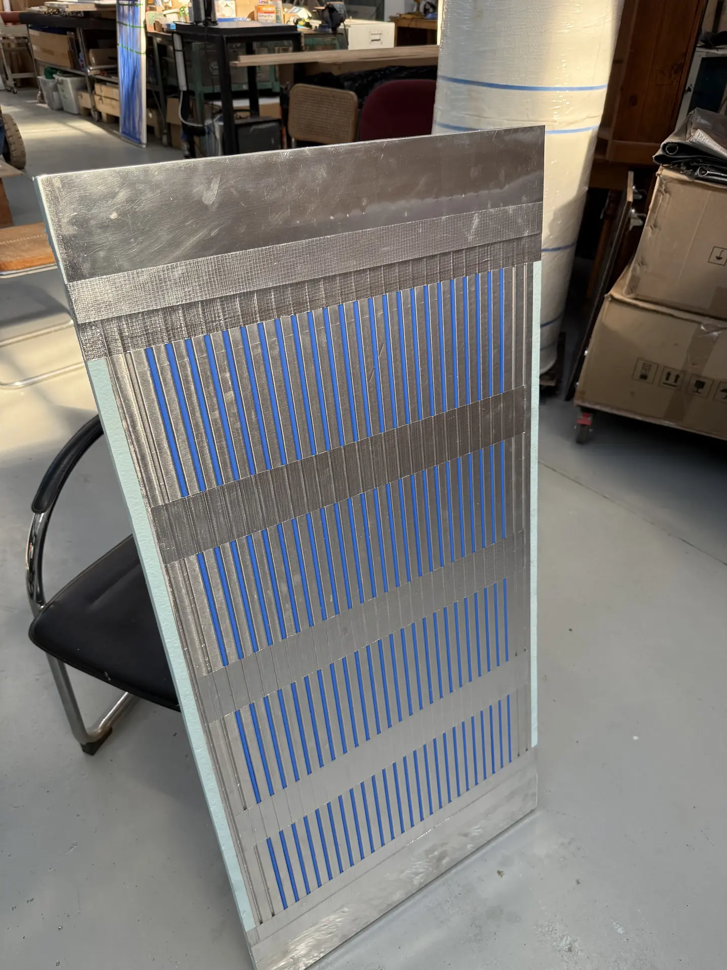 Completed panel showing capillary tubes bonded to foil insulation, front view in workshop