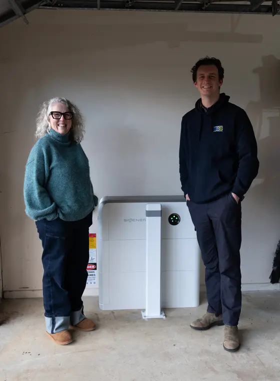 Happy EES customer beside a new home battery